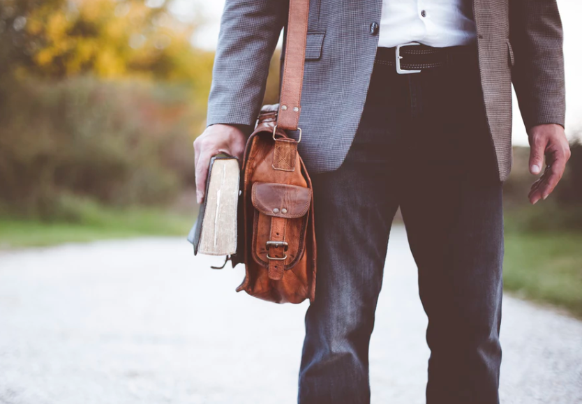 man standing in the road with a Bible